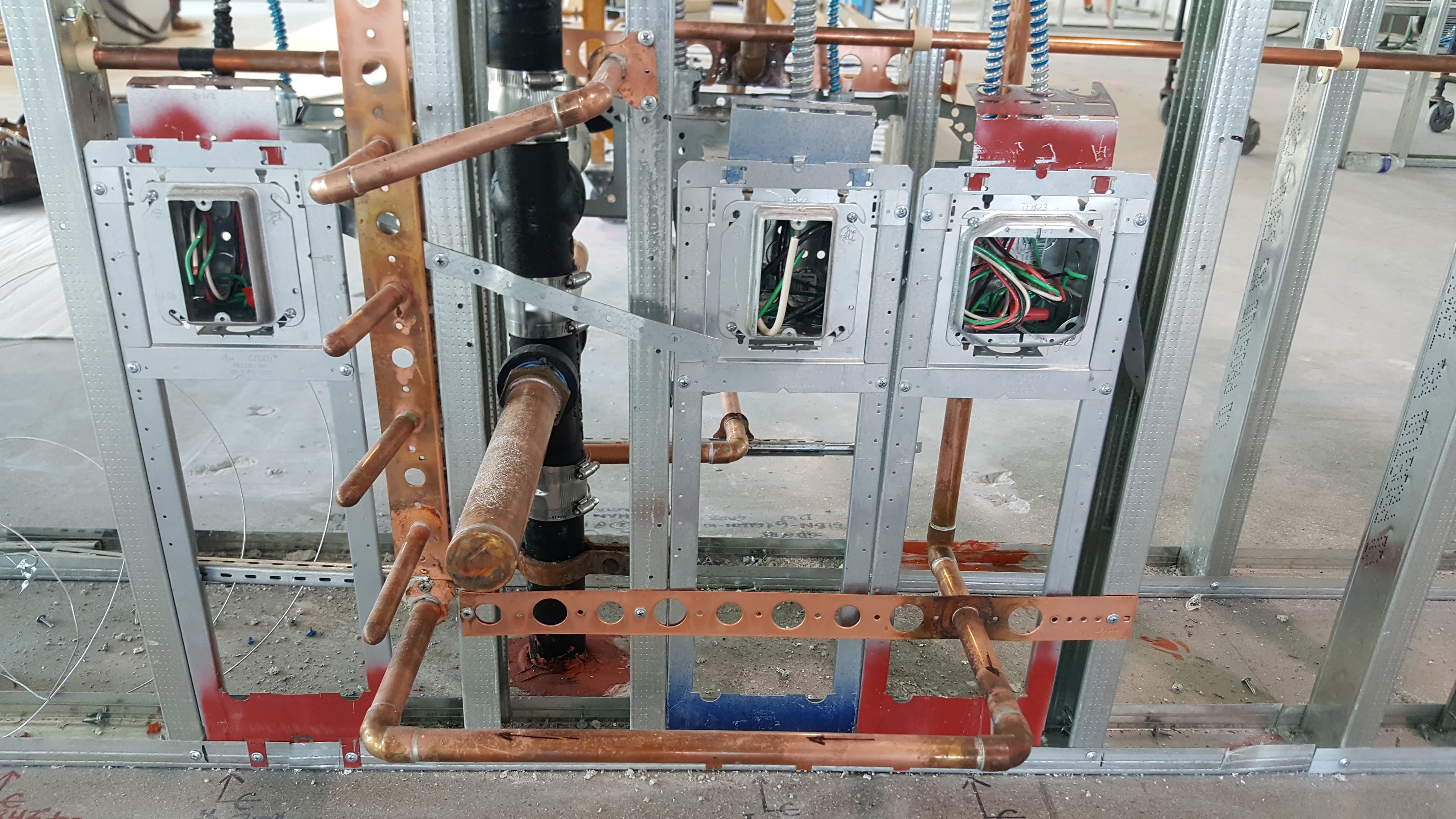 Commercial rough plumbing with multiple copper supply branches and supports.